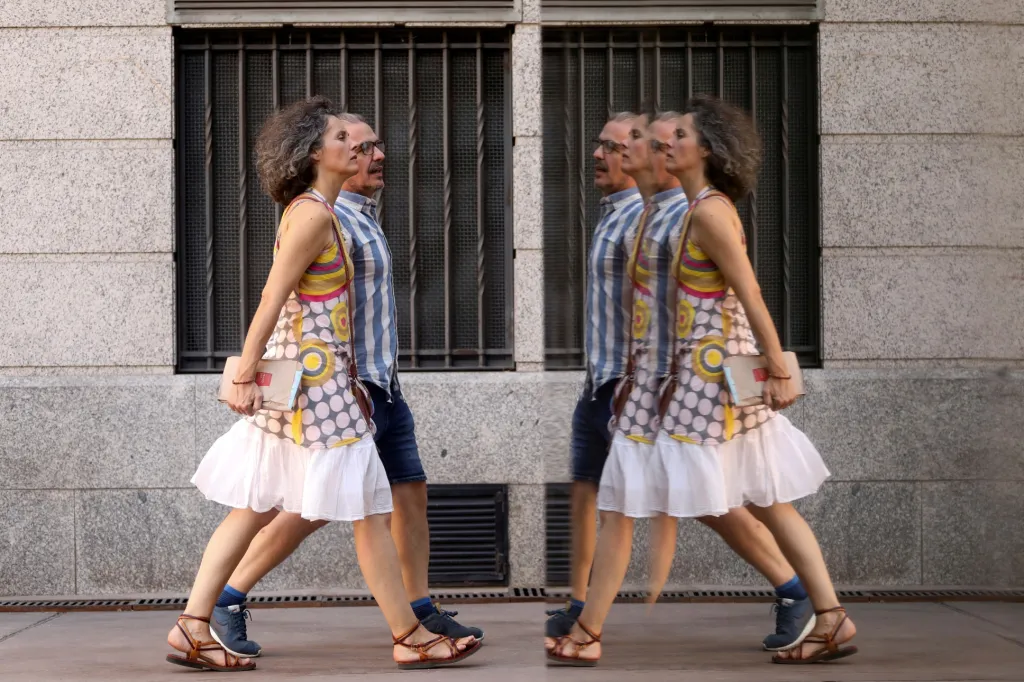 Zvlášní fotografie vznikla v Madridu, kde se procházející se pár odráží ve skleněné stěně poblíž kulturního centra CaixaForum