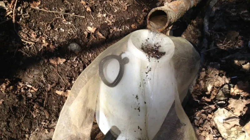 Pramen vody vtéká do plastového barelu