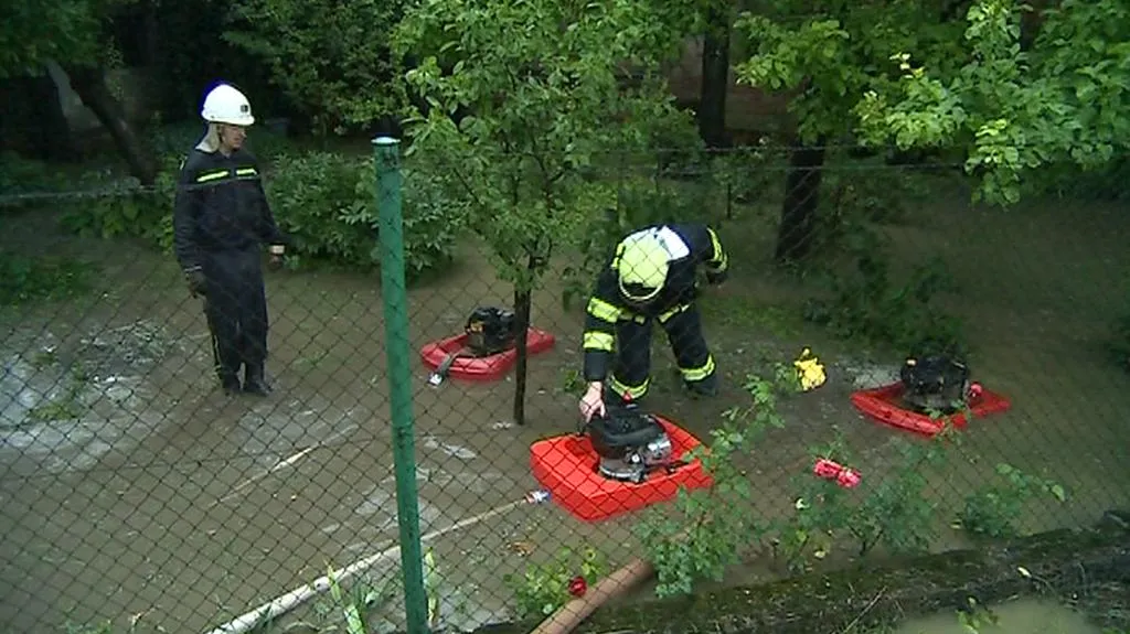 Hasiči odčerpávají vodu ze zatopené zahrady