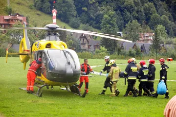 Lidé stojí pod vrcholem Giewont ve frontách a drží se řetězů, popisují místo neštěstí polská média