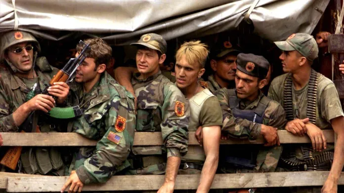 Příslušníci Kosovské osvobozenecké armády (UČK) na korbě nákladního vozu, který je veze do kasáren v Prizrenu (17. 6. 1999)
