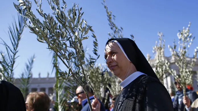 Jeptiška s palmovou ratolestí čeká na začátek papežovy mše při Květné neděli