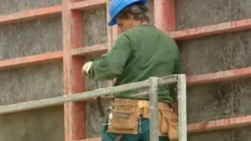 Dělník zatepluje dům