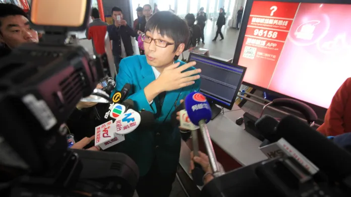 Zaměstnanec společnosti Malaysia Airlines odpovídá na dotazy novinářů