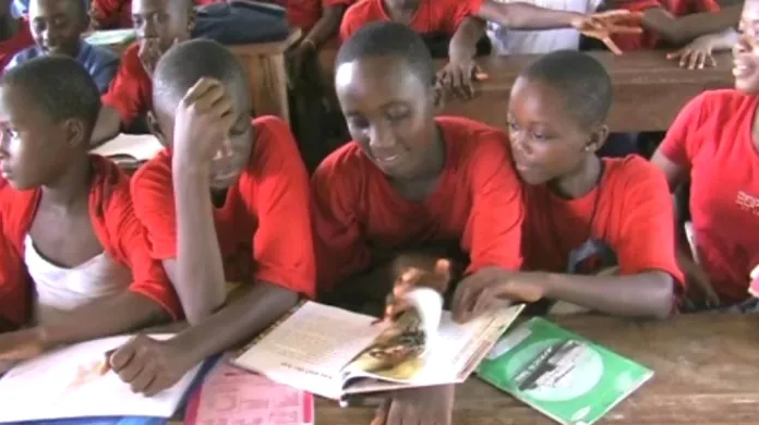Africké děti si listují knížkou gorilích pohádek