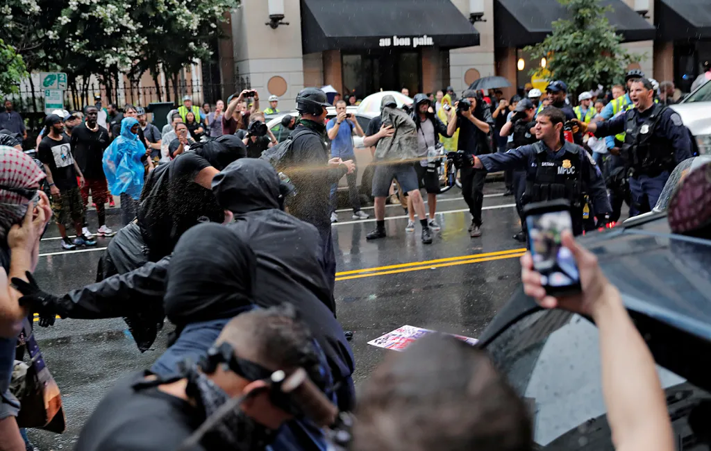 Policejní strážníci při použití pepřových sprejů ve Washingtonu během demonstrace nacionalistů k výročí událostí v Charlottesville v srpnu 2018