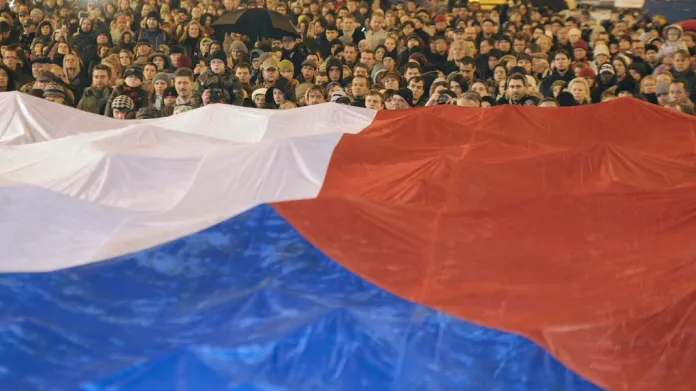 Lidé při shromáždění na Václavském náměstí roztáhli obří českou vlajku