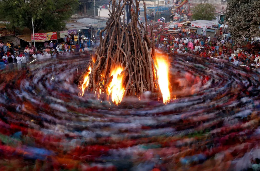 Lidé v předvečer hinduistického svátku Hólí zapalují ohně a rituálně kolem nich chodí nebo tančí. Město Ahmedabad v Indii