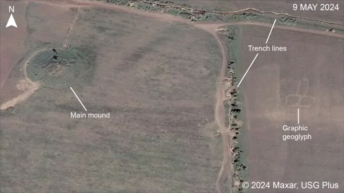 Poškozený kurgan v levé části fotografie, zákopy a moderní geoglyf na pravé straně