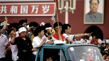 Protestující přijíždějící na náměstí Nebeského klidu, aby se připojili k dalším pro-demokratickým demonstrantům, když zrovna projíždějí kolem portrétu Mao Ce-tunga. Snímek pořízen v květnu 1989