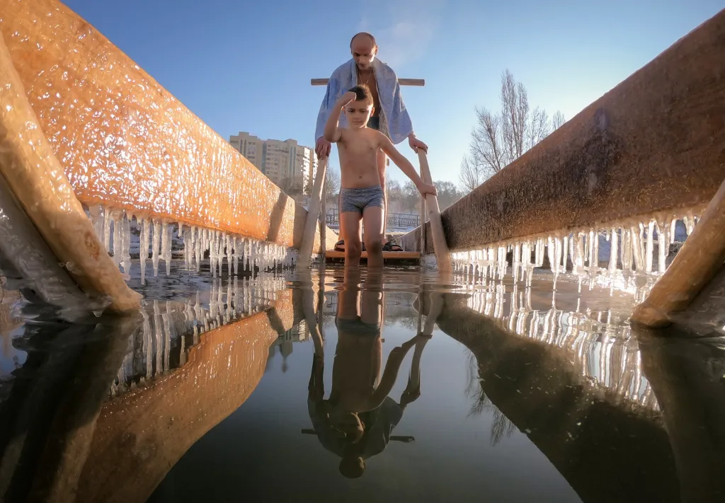 Chlapec si žehná před vstupem do vody Bolšaja Almatinka v Almaty