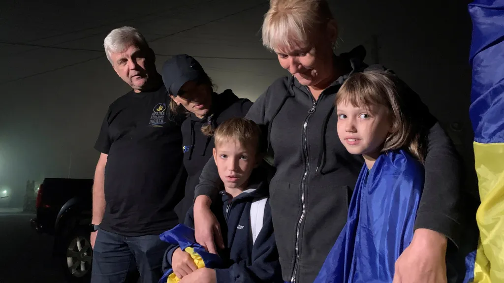 Matka objímá své děti, které se vrátily z okupované části Ukrajiny