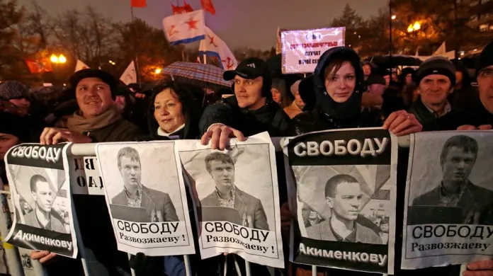 Demonstranti drží portréty zadržovaných aktivistů