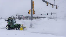 Pracovník v Des Moines odstraňuje sníh z chodníku