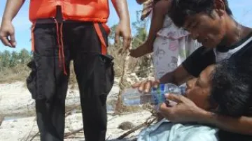 Záchranáři pomáhají ženě, která přežila tsunami na ostrově Pagai