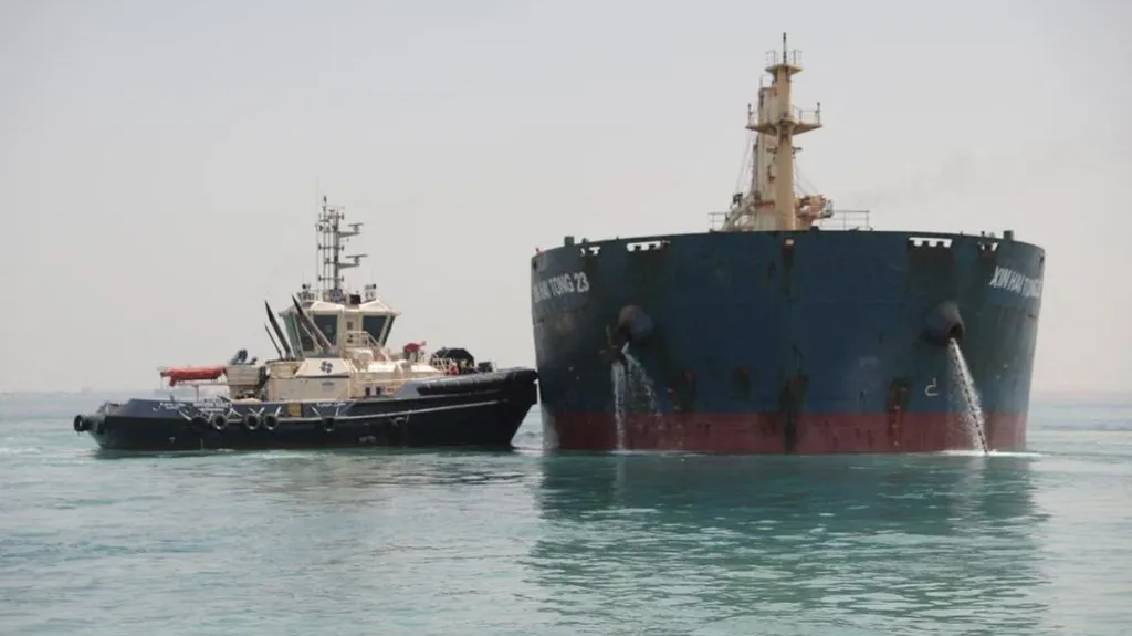 Remorkér pomáhá lodi uvázlé v Suezském průplavu