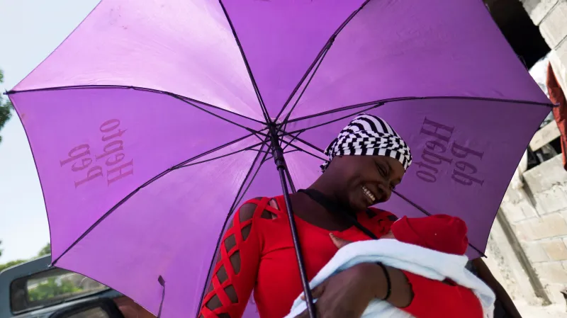 Žena s novorozenětem v domově pro rodiny ohrožené gangy v haitském hlavním městě