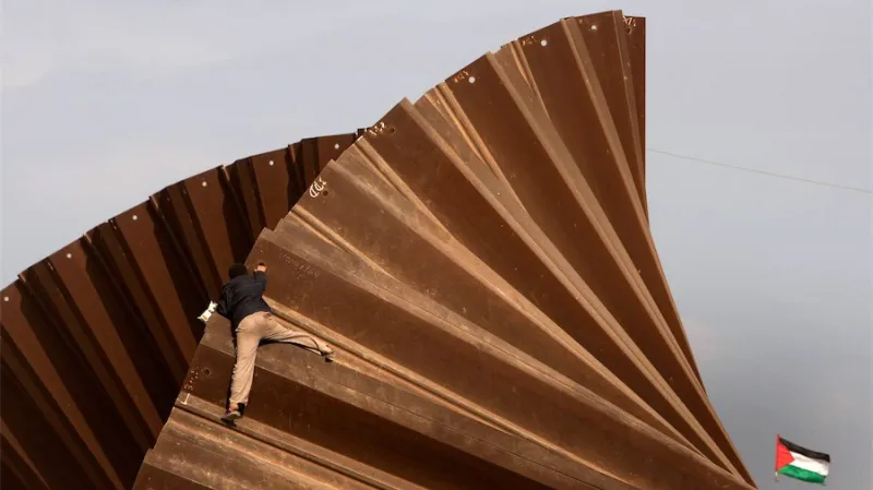 Palestinský chlapec na hraniční zdi mezi Gazou a Egyptem