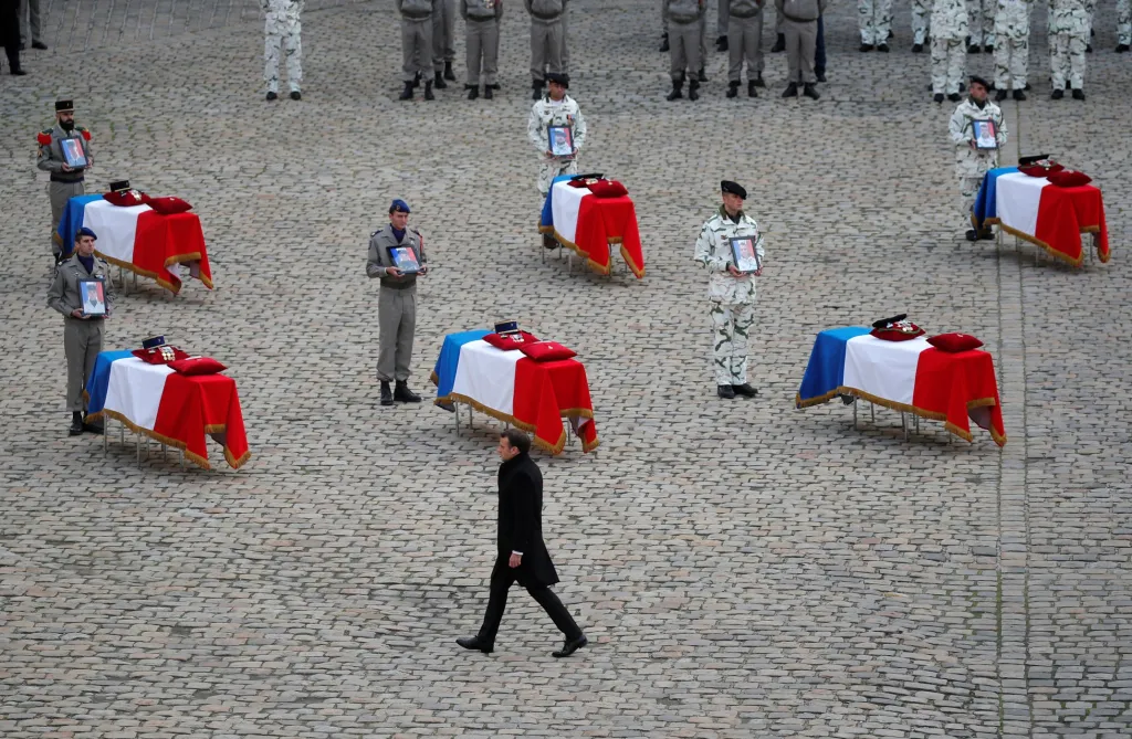 Francouzský prezident Emanuel Macron prochází kolem rakví vojáků padlých při nehodě helikoptéry v Mali