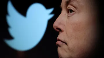 Elon Mask před logem Twitteru