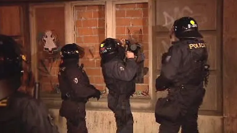 Policisté s beranidlem vnikají do domu