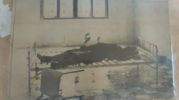 Snímek fotografie k smrti umučeného vězně, jak byl nalezen po osvobození věznice