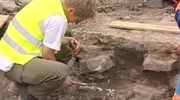 Archeolog odkrývá zbytky studny