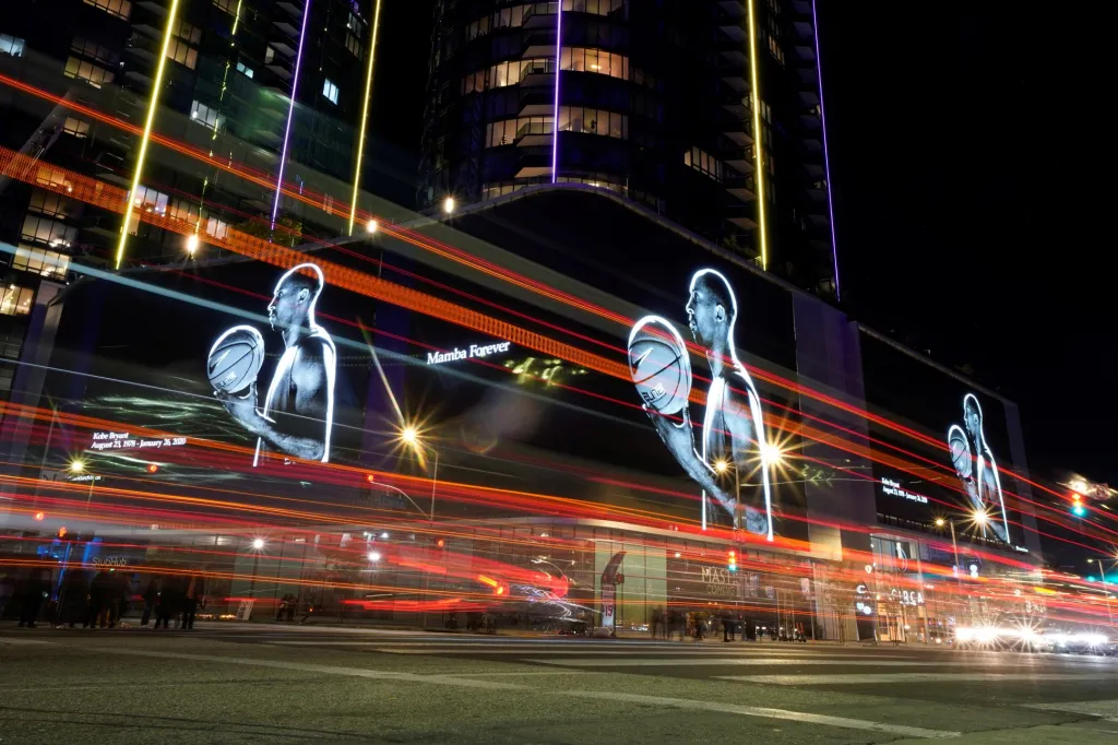 Svět se rozloučil s ikonou světového basketbalu Kobe Bryantem. Fanoušci po celém světě uspořádali desítky happeningů. V Americe bylo rozvíceno stovky budov v barvách jeho dresu. Na snímku je budova Staples Centra v Los Angeles, která připravila speciální projekci