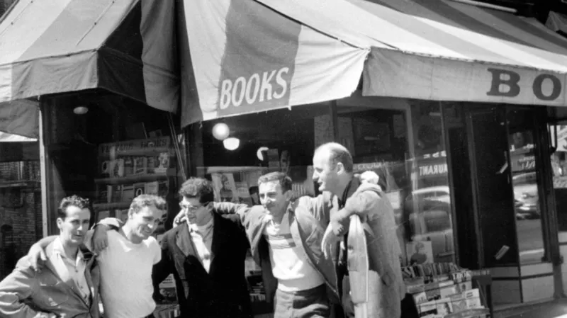 Allen Ginsberg (uprostřed) a Lawrence Ferlinghetti (vpravo na kraji) stojí před knihkupectvím City Lights v roce 1956