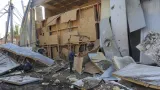Zaměstnanci odklízejí trosky v areálu zemědělského podniku v Oděské oblasti na Ukrajině, který v neděli večer zasáhl ruský raketový útok (22. června 2026)