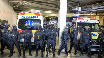 Policejní těžkooděnci hlídají odjezd fotbalistů Sparty ze stadionu