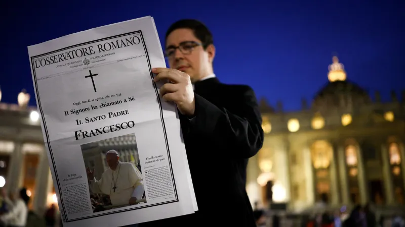 Kněz si čte zprávy o úmrtí papeže