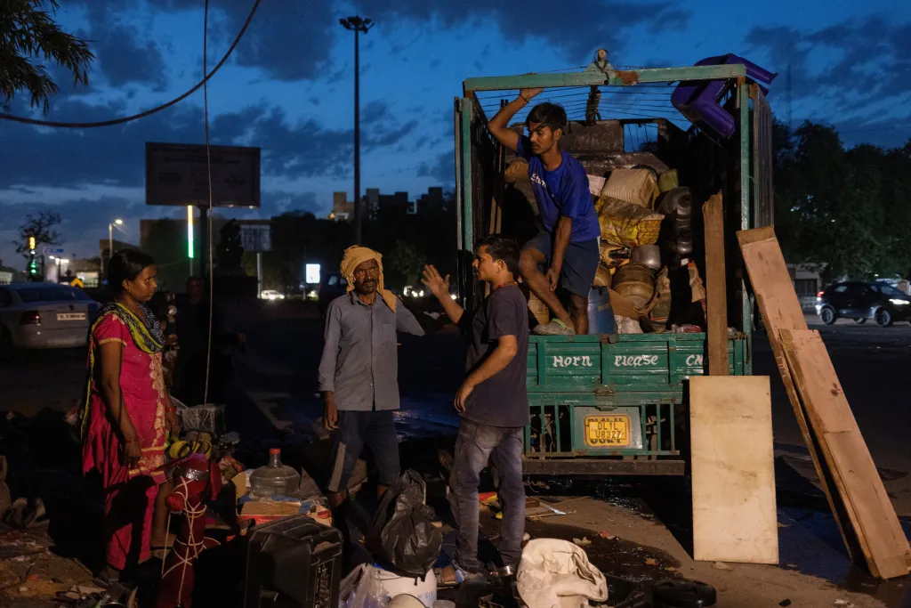 Obyvatelé slumu nakládají své věci do auta