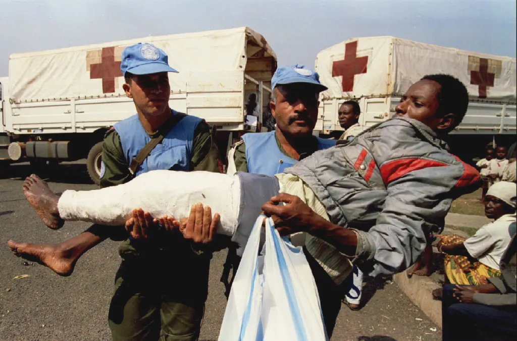 Tuniští vojáci jednotek OSN nesou jednoho ze 45 těžce zraněných lidí evakuovaných 27. června z úřadu vlády v Kigali