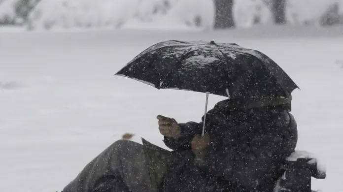 Muže v Bělehradu neodradilo od posezení v parku ani silné sněžení
