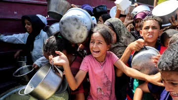 Palestinci před charitativní kuchyní v Chán Júnisu v jižní části pásma Gazy (21. srpna 2025)