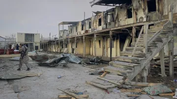 Voják Talibanu prochází kolem rehabilitační nemocnice pro drogově závislé, která byla zničena při leteckém útoku na Kábul