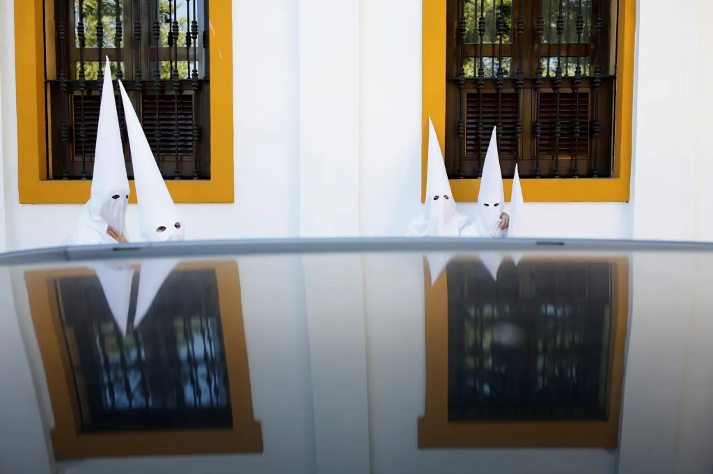 Kajícníci z bratrství La Paz se vydali do kostela během procesí Svatého týdne v andaluském hlavním městě Seville v jižním Španělsku, 14. dubna 2019