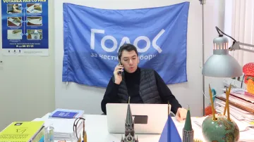 Grigorij Melkonjanc před plakátem organizace Golos