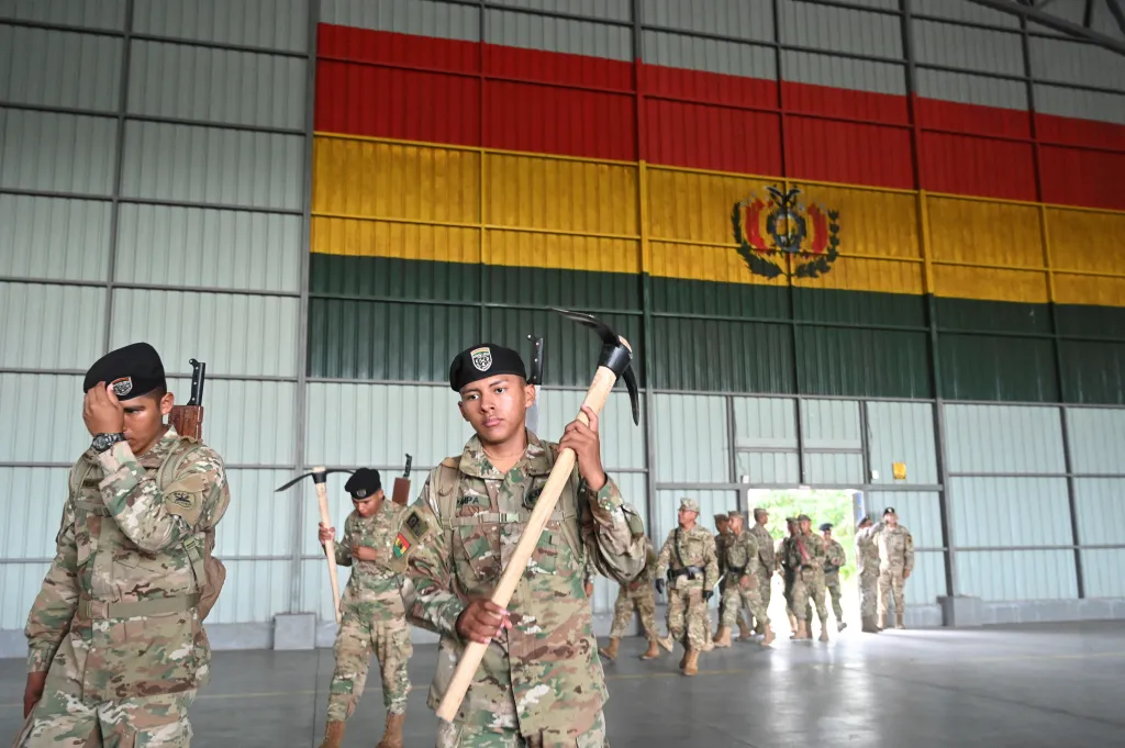 Bolivijští vojáci nesou krumpáče