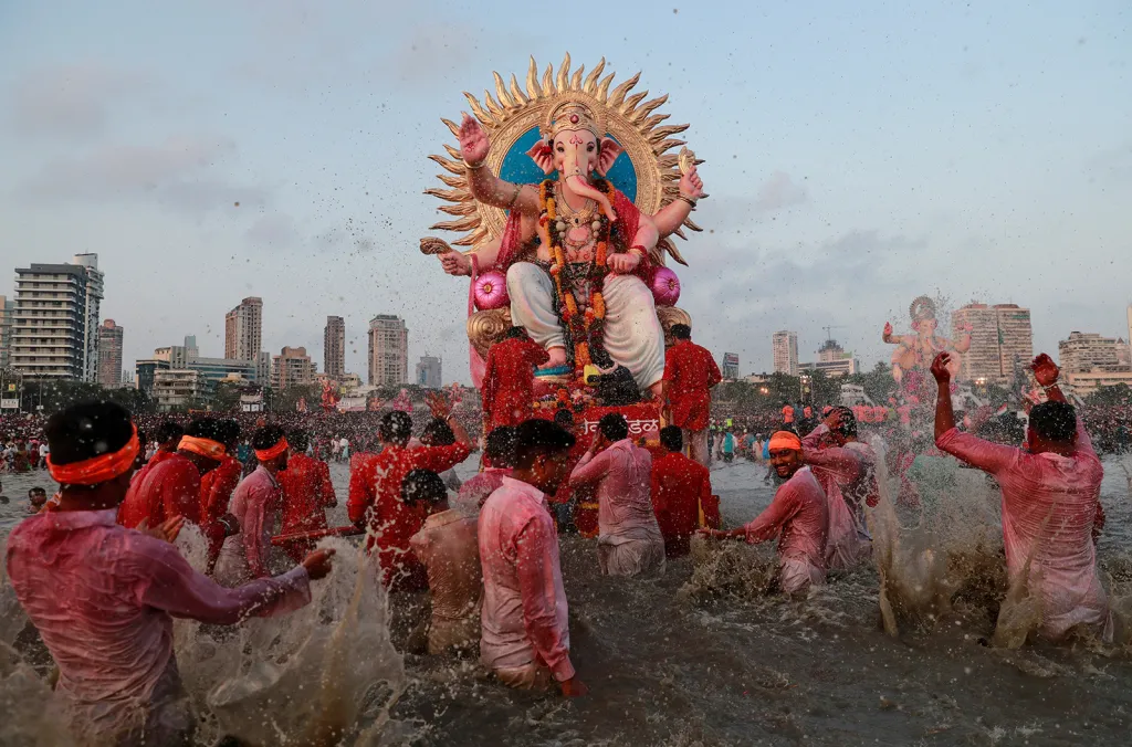 Účastníci hinduistického festivalu Ganéš Čaturthi stříkají vodu na ikonu boha Ganéši, kterou nesou k potopení do Arabského moře v poslední den svátku v indické Bombaji