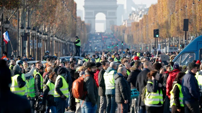 Lidé v žlutých vestách, které si oblékli na symbol protestu francouzských řidičů proti vyšším cenám pohonných hmot na Champs- Élysées v Paříži