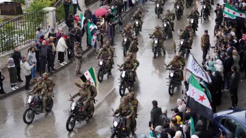 Syřané sledují vojenskou přehlídku u příležitosti oslav 1. výročí pádu Bašára Asada