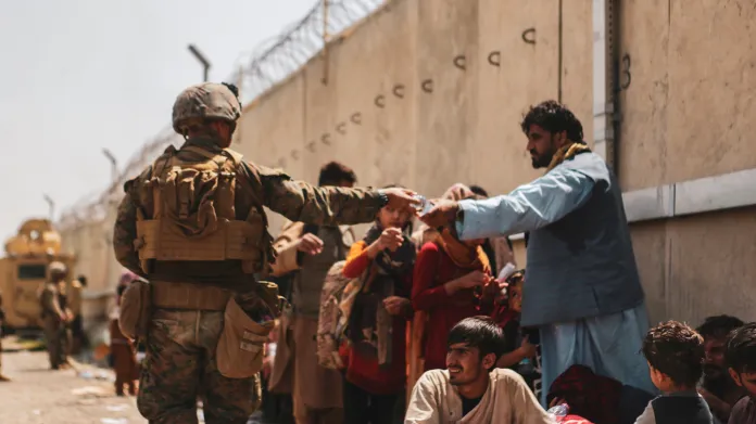 Americký voják roznáší vodu Afgháncům čekajícím na kábulském letišti
