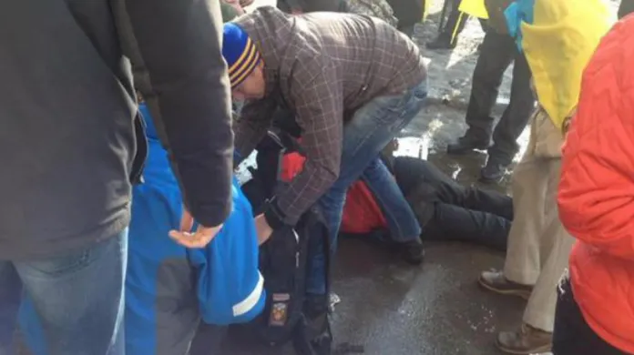 Lidé po výbuchu v Charkově pomáhají zraněným