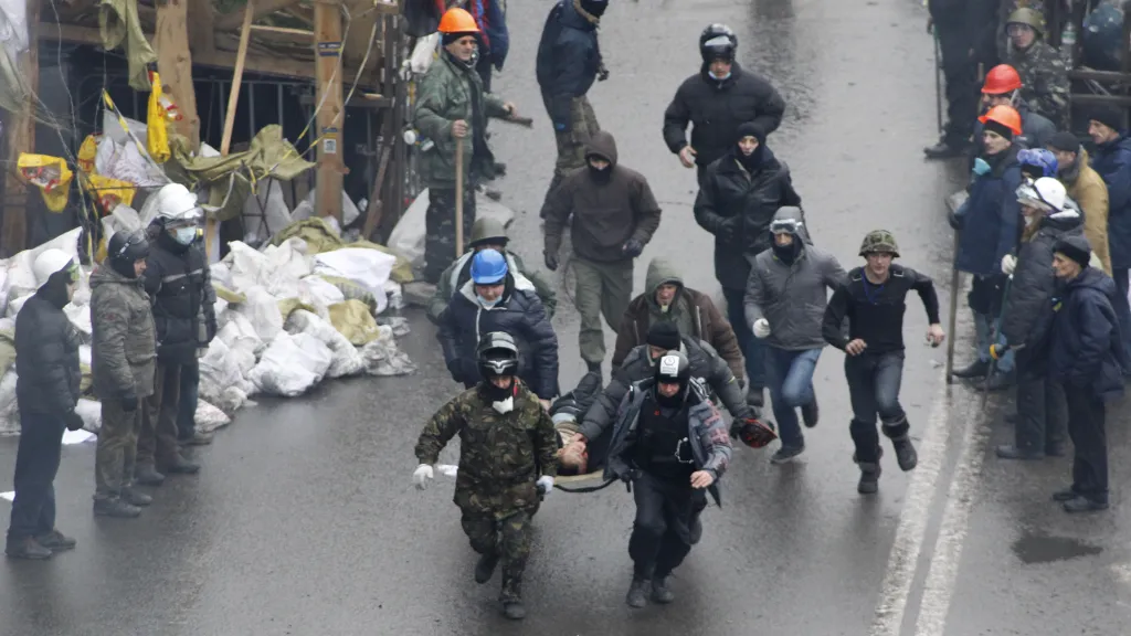 Raněný demonstrant po policejní střelbě, 20. únor 2014 na Majdanu