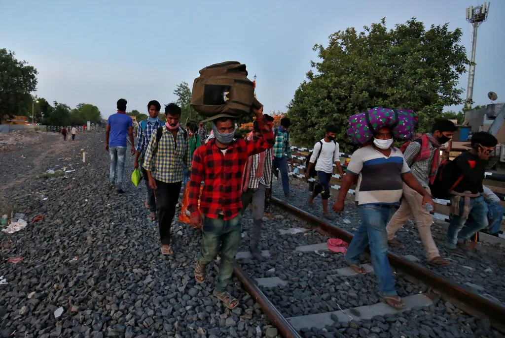 Z těchto důvodů se tisíce lidí vydaly na cestu domů pěšky. Někteří přecházejí obrovské vzdálenosti. Snímek je vyfocen kousek od města Ahmadábád
