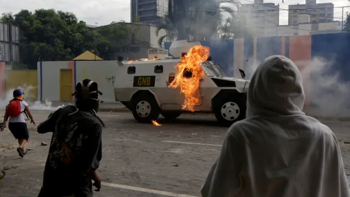 Stoupenci opozice při protestech zapálili obrněné auto policie