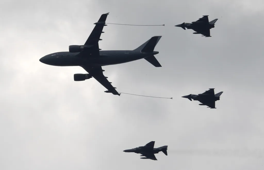 Airbus A310 MRTT je vojenský speciální letoun určený k přečerpávání paliva za letu. Tato „vzdušná benzinka“ je doprovázena na snímku letkou stíhaček  Eurofighter Typhoona F4 Phantom. na Mezinárodní letecké show v Schönefeldu u Berlína v roce 2010