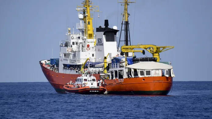 Loď Aquarius se člunem italské pobřežní hlídky, který převzal část migrantů z přetíženého plavidla